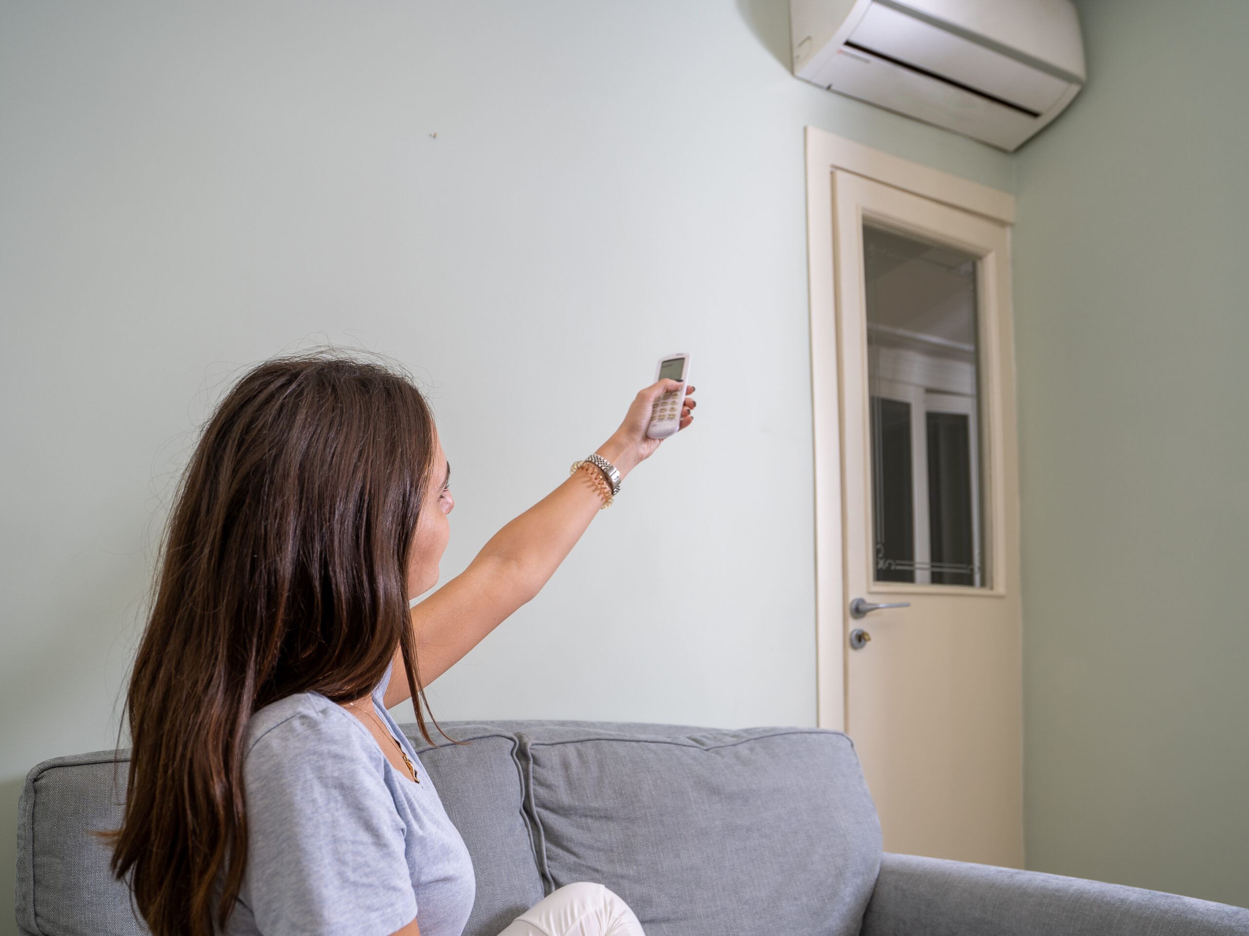 She is trying to adjust the temperature of her ac